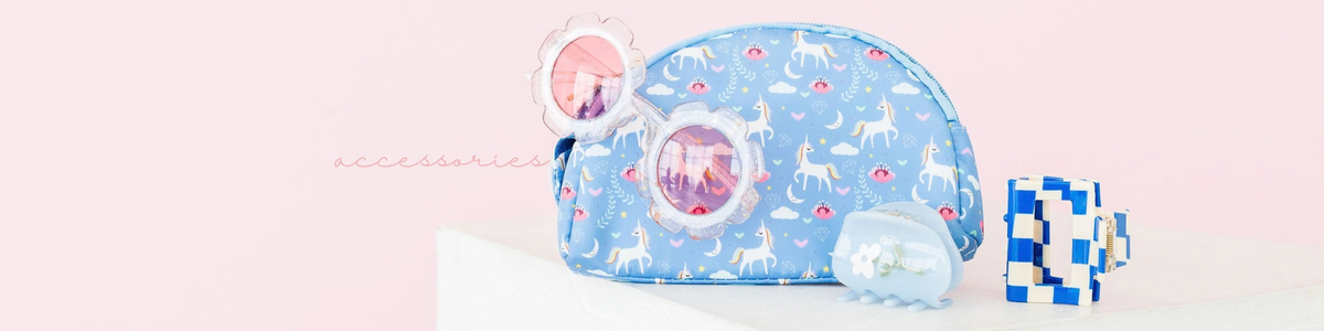 Blue unicorn-print makeup bag with flower-shaped sunglasses and checkered hair clips on a white surface.