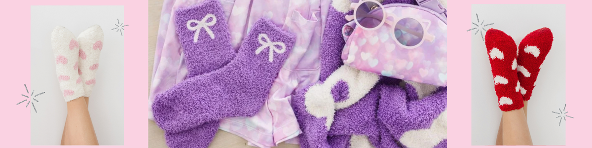 Cozy girls' fuzzy socks in purple, white, and red with heart and bow patterns, styled with matching accessories.