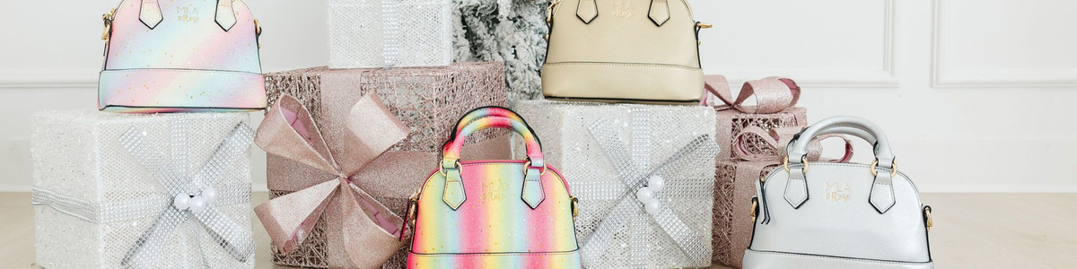 Mila & Rose handbags in metallic, glitter, and rainbow finishes displayed among festive, sparkling holiday gift boxes.