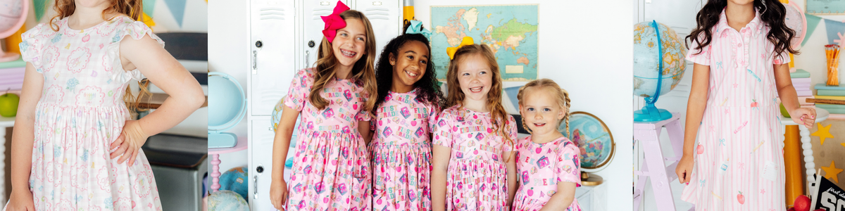 Group of girls wearing pink short-sleeve back-to-school dresses with colorful school supply and grade level patterns.