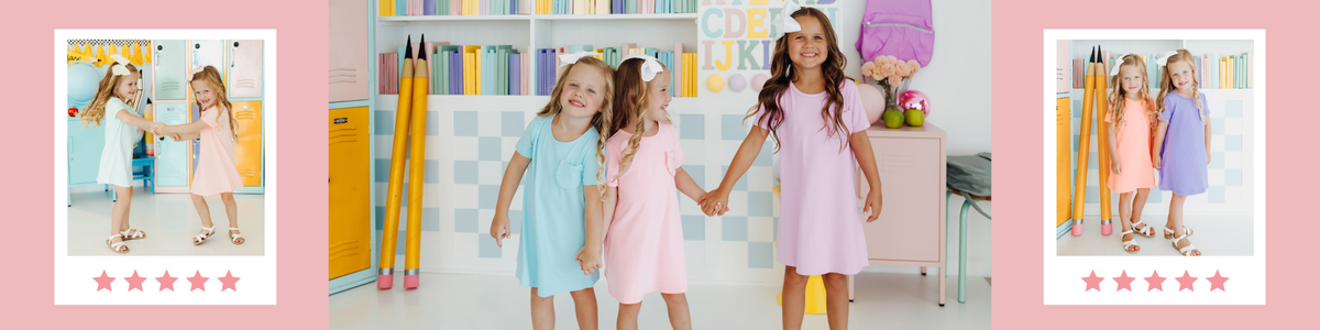 Two young girls wearing soft, colorful t-shirt dresses standing in front of pastel school lockers.