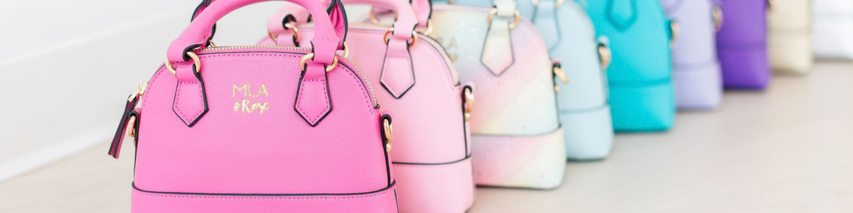 A row of colorful, dome-shaped purses in vibrant pink, pastel, and bright shades with gold hardware.