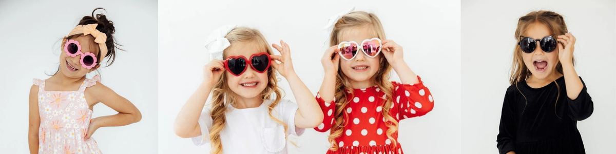 Young girls wearing playful, colorful heart and flower-shaped sunglasses from the Sunnies collection.