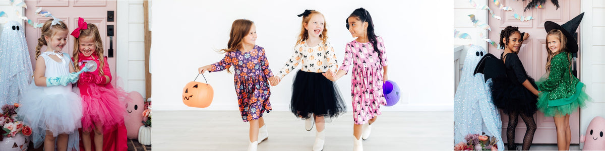 Three girls wearing purple long-sleeve Halloween dresses featuring ghost, pumpkin, and floral patterns.